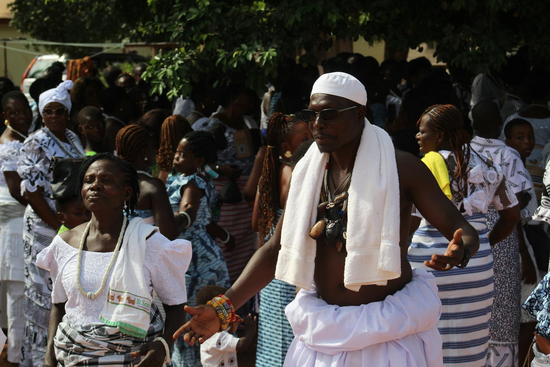 Bright traditional African gathering with people in cultural attire, celebrating outdoors.