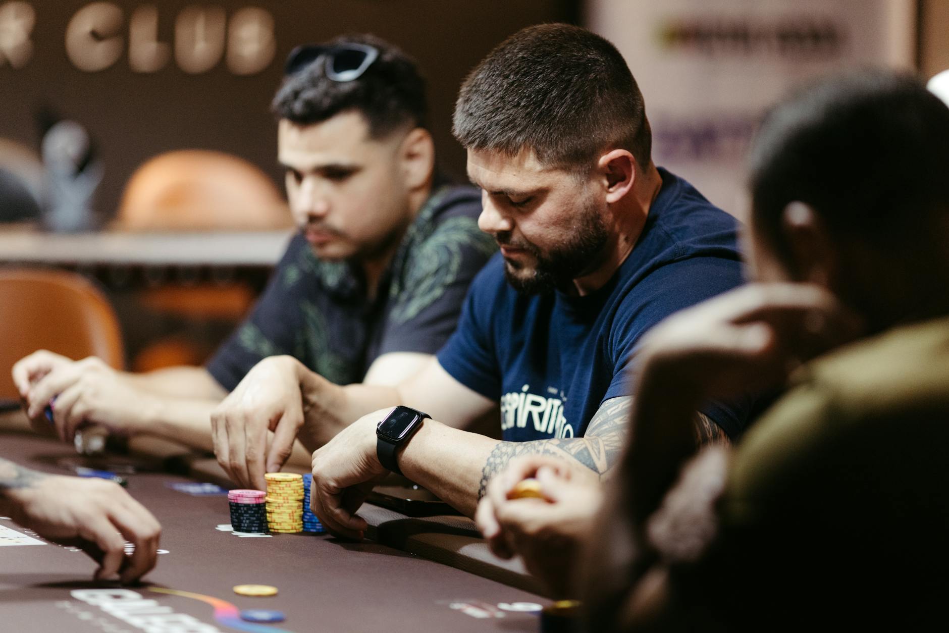 Players focused on a poker game at a casino table, showcasing intense strategies and concentration.