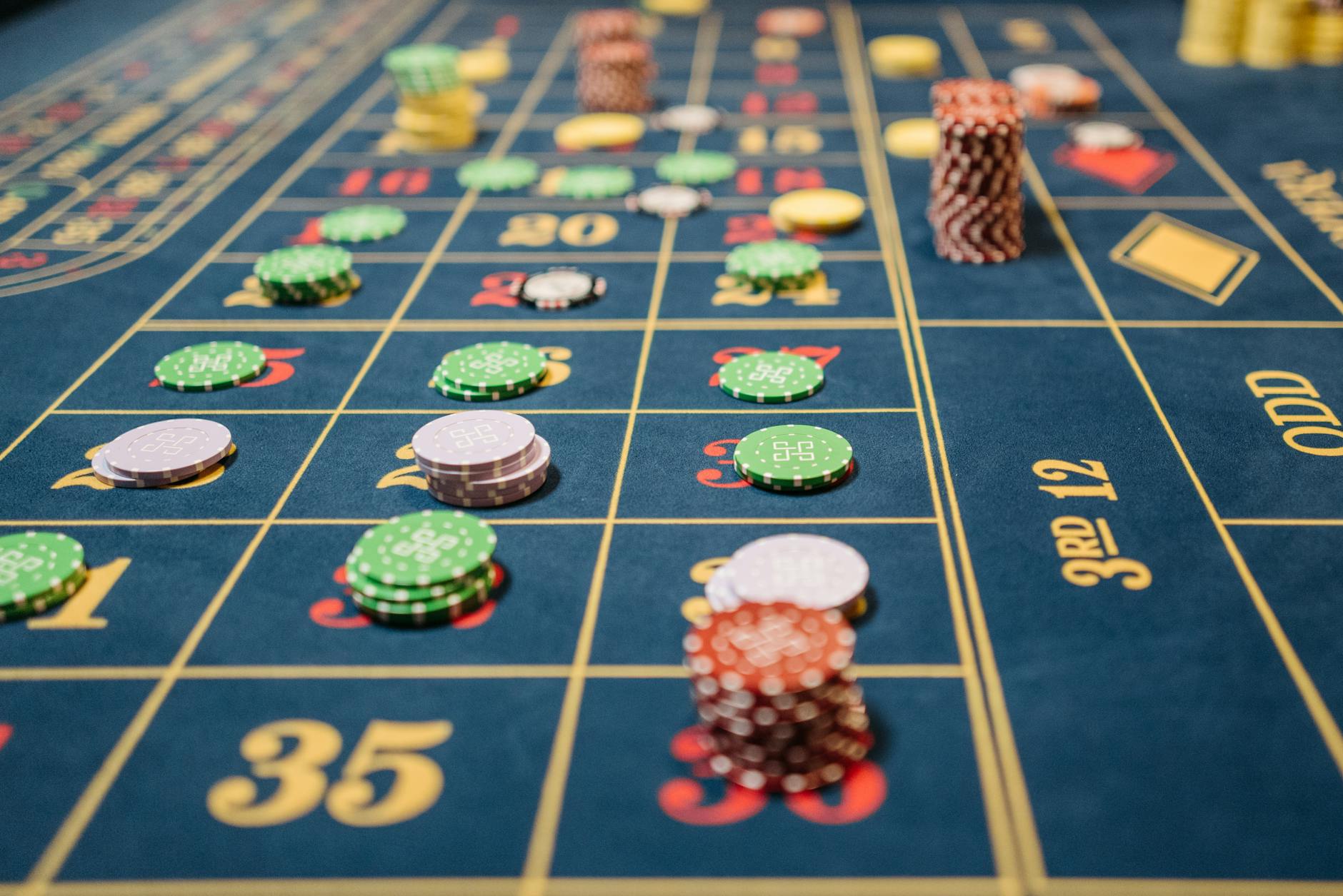 Close-up of a roulette table with colorful poker chips, capturing the thrill of casino gambling.